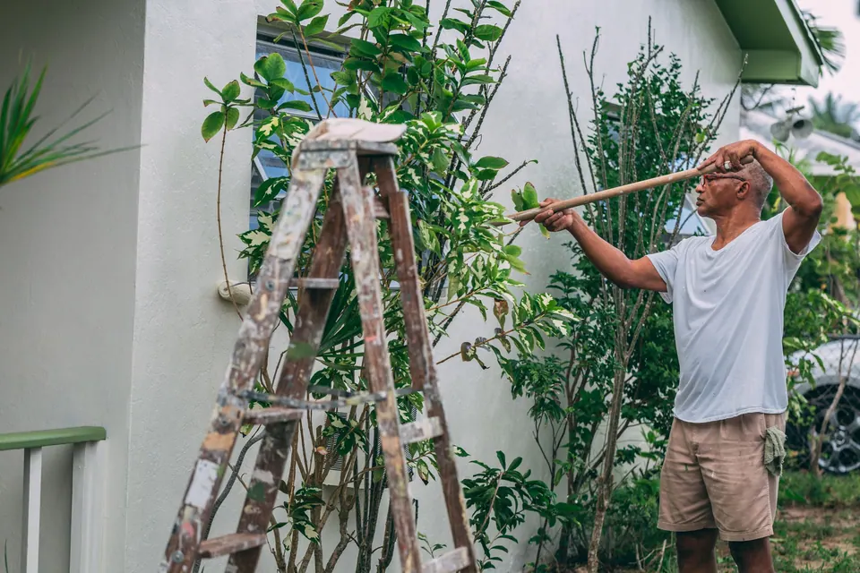 Peintre appliquant une finition sur une façade extérieure