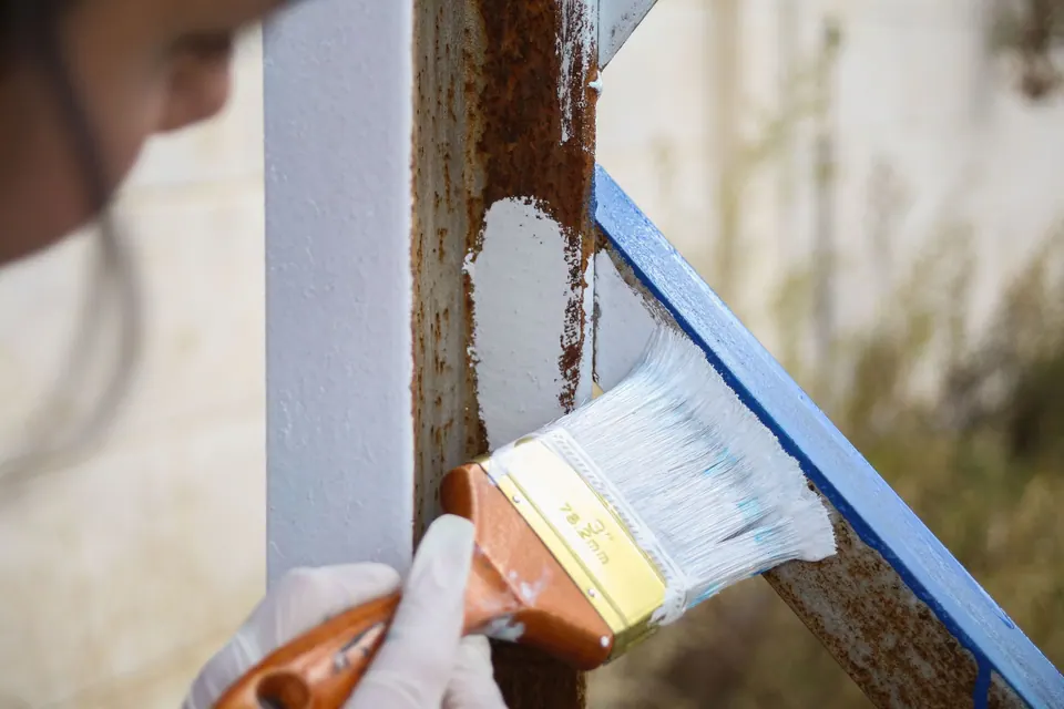Application de peinture au pinceau sur une rambarde métallique